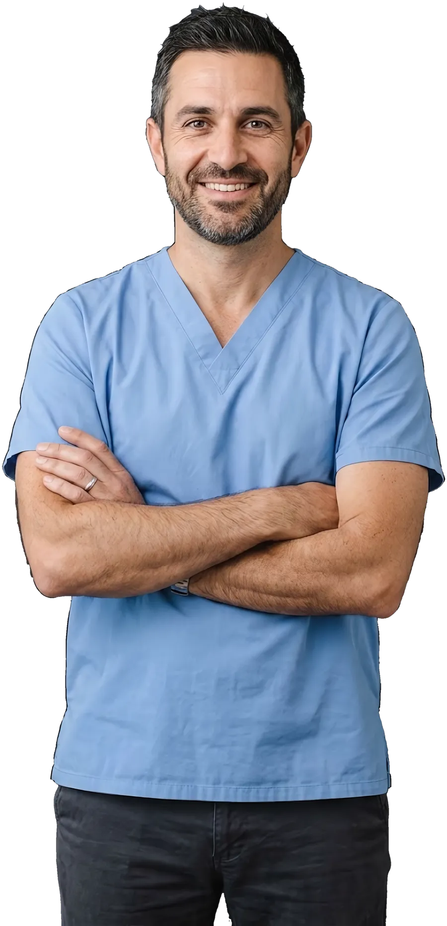 A dentist in a clinic top, arms crossed, smiling