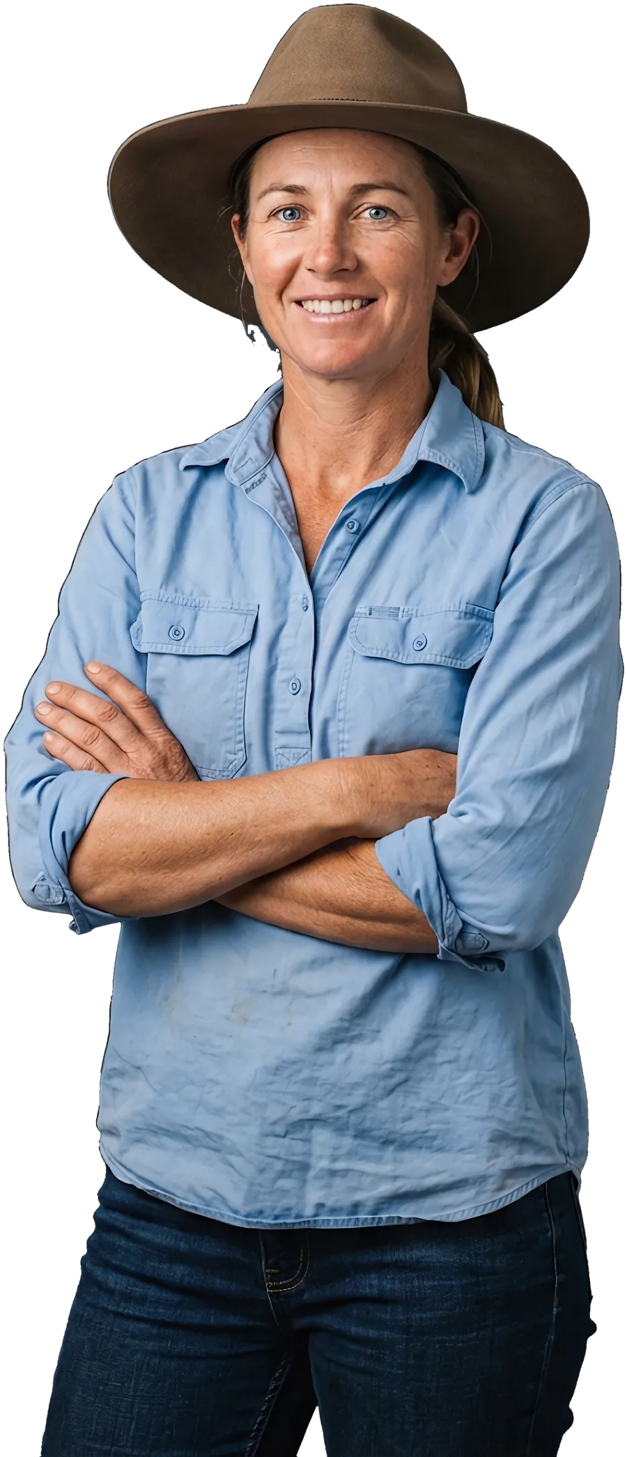 A farmer in a work shirt and hat, arms crossed, smiling